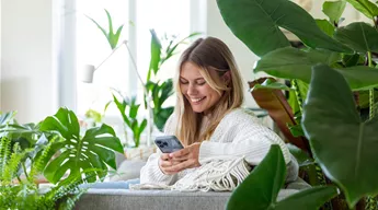 Jungle Ambiente - Frau mit Handy auf dem Sofa