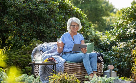 Gartenfreizeit - Frau mit Tablet im Garten 